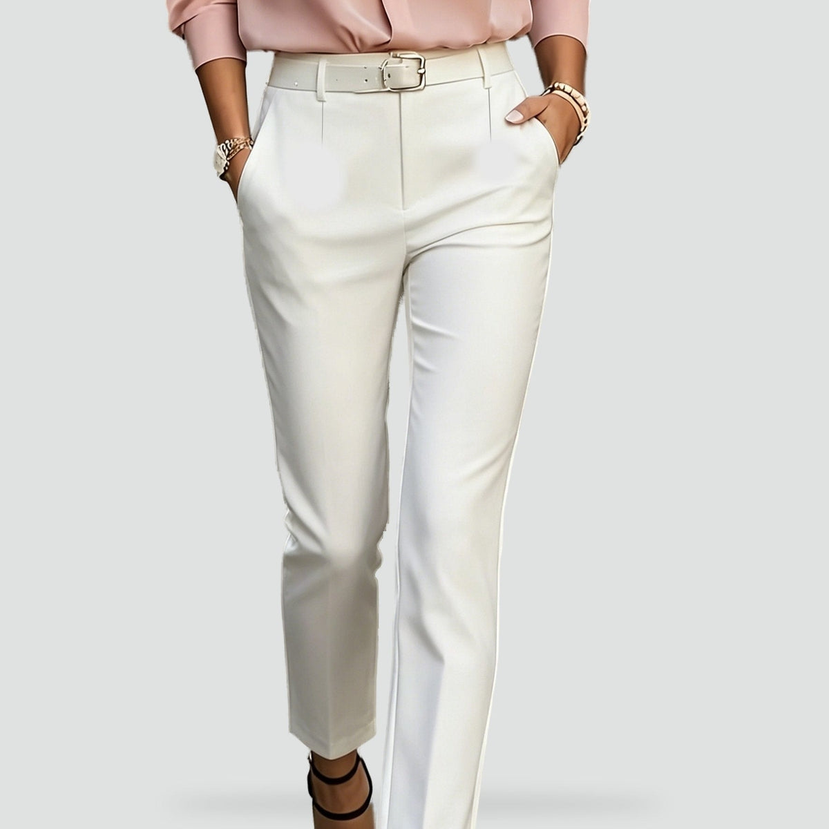 Close-up of white slim-fit trousers highlighting the clean waistband and angled pocket design.