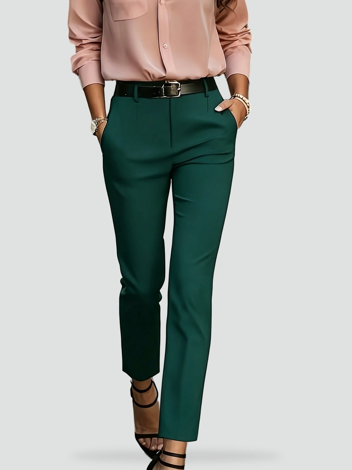 Green ankle-length slim-fit trousers shown with a high waist, belt loops, and hands resting in the side pockets.