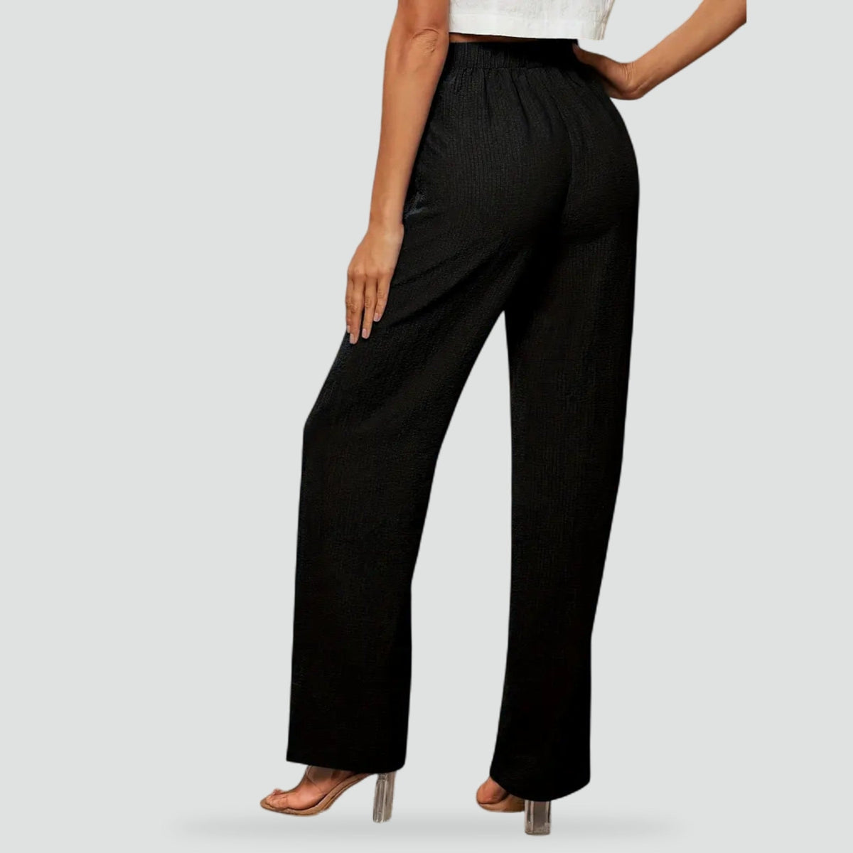 Back view of black high-waisted straight-leg trousers, showing the smooth waistband and full-length hems.