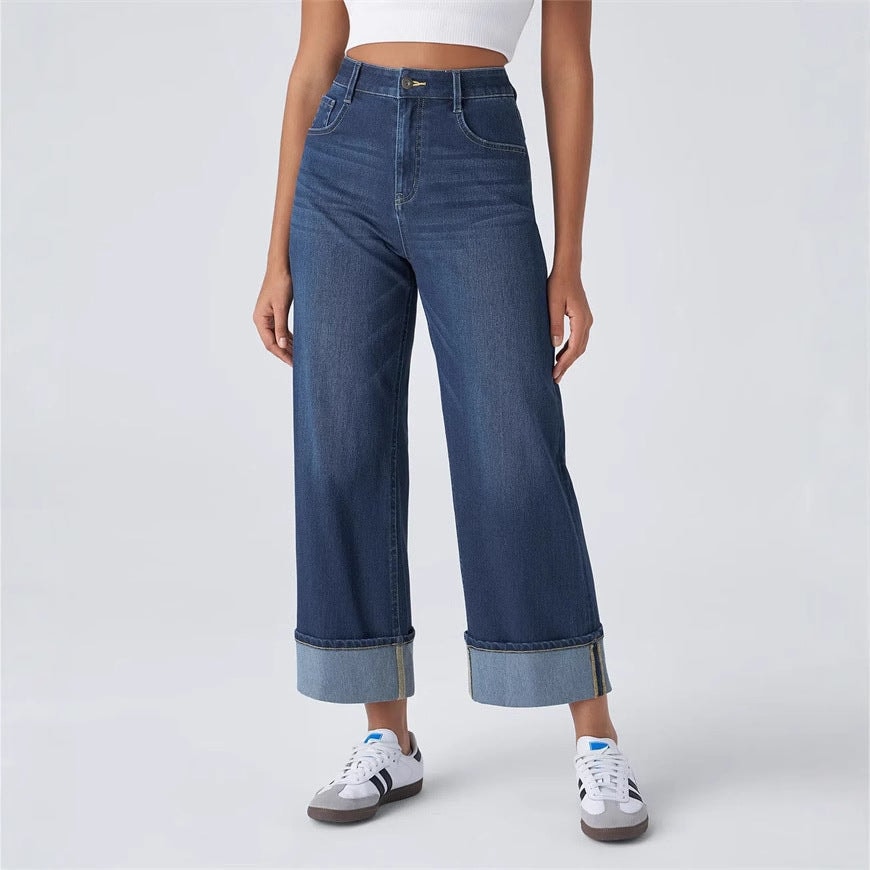 Full front view showing the jeans’ relaxed wide-leg silhouette, high waistband, front pockets, and contrasting turned-up hems.