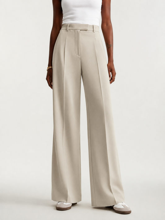 Front view of beige high-waisted tailored trousers with wide legs, front pleats, belt loops, and full-length hems.