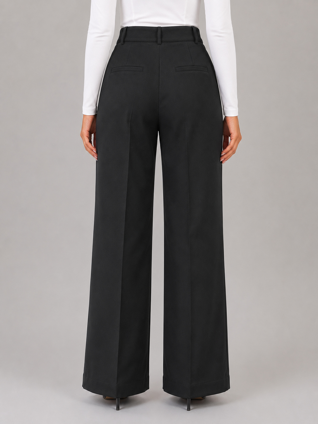 Back view of black wide-leg trousers showing the high waistband and two welt back pockets.