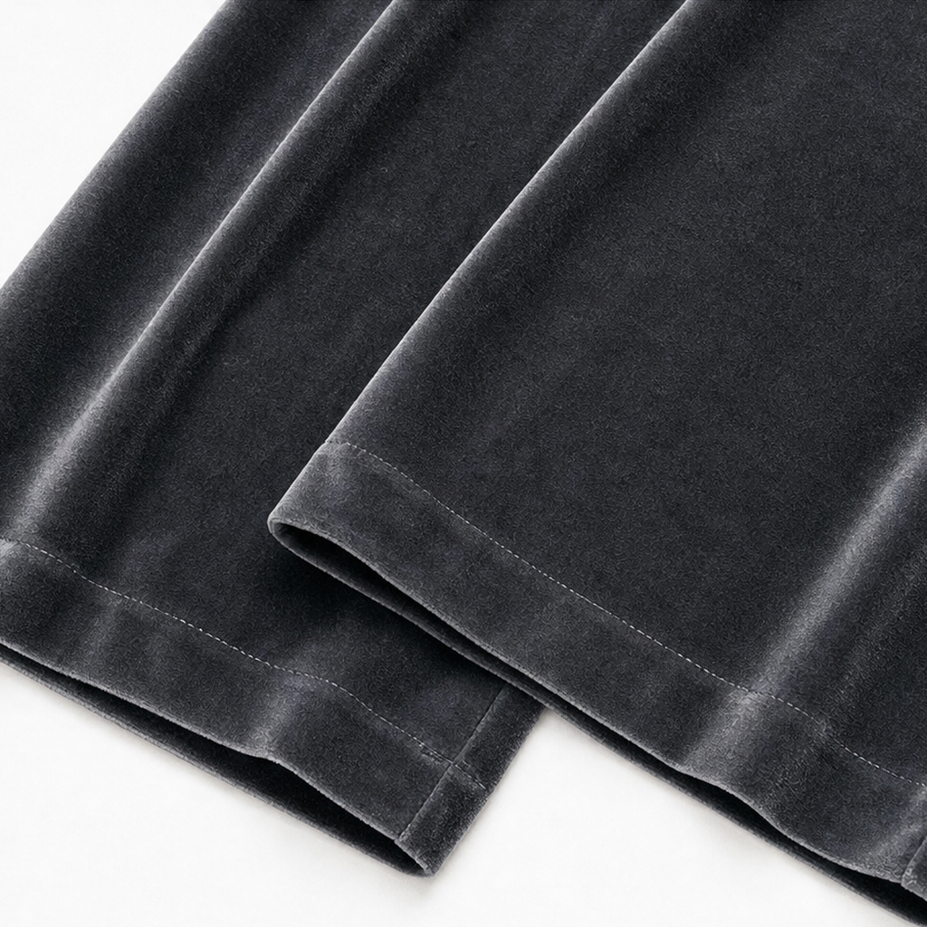 Close-up of the wide trouser hems showing finished edges and flowing velvet-look texture.