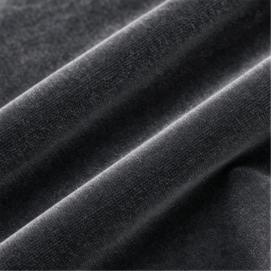 Close-up of the trousers’ dark velvet-look surface with soft sheen and visible raised texture.