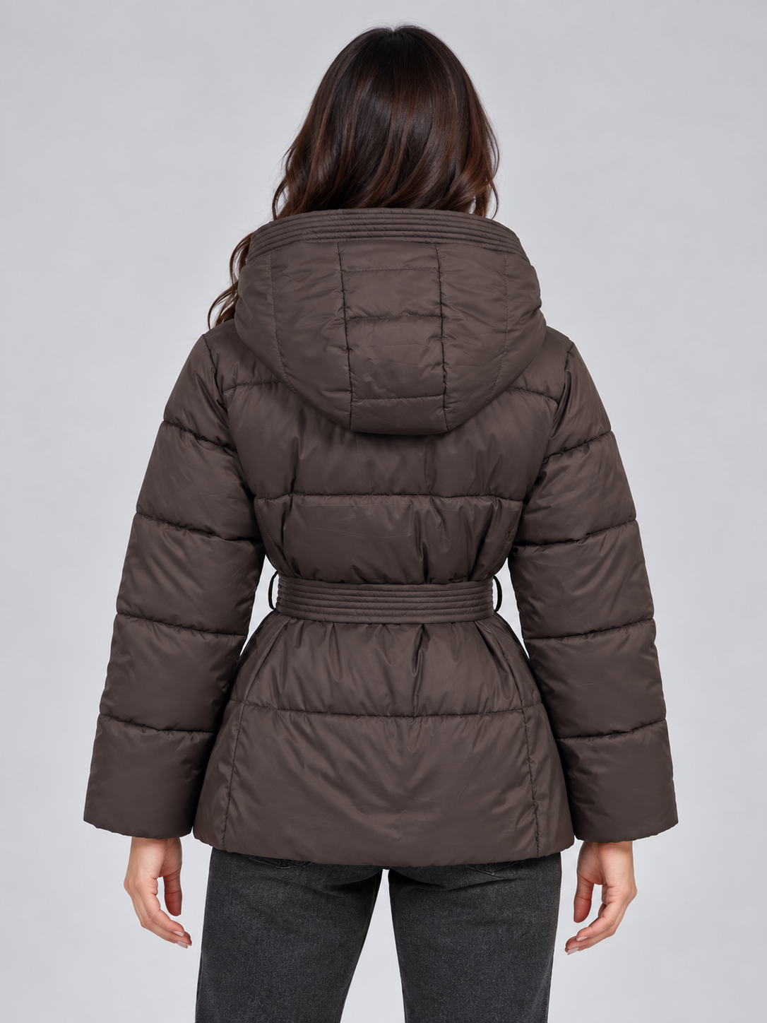 Back view of the brown quilted puffer jacket, showing its padded hood, horizontal quilting, long sleeves, and belt cinching the waist.