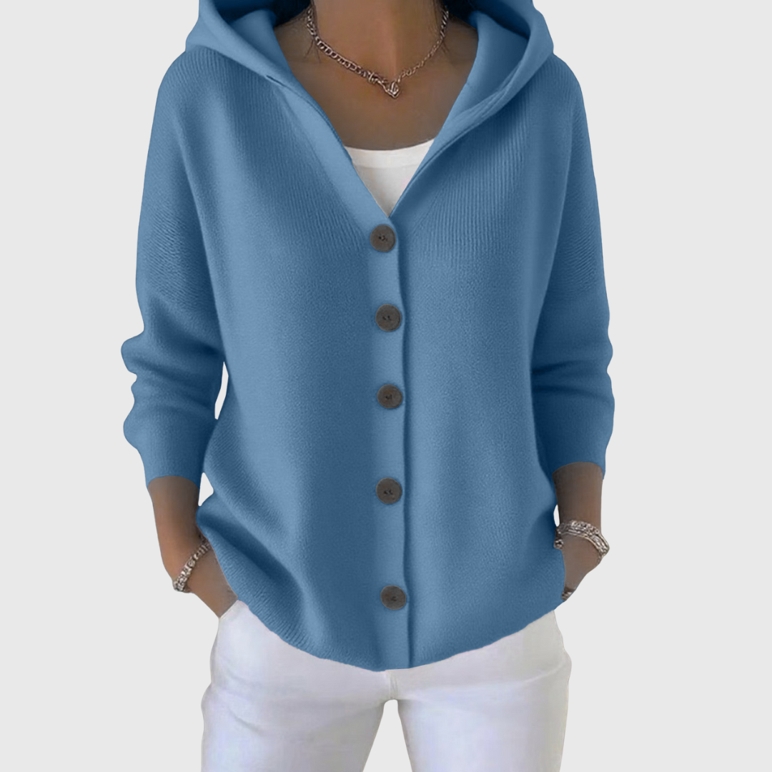 Blue hooded cardigan with long sleeves, front buttons, and a curved hem above white trousers.