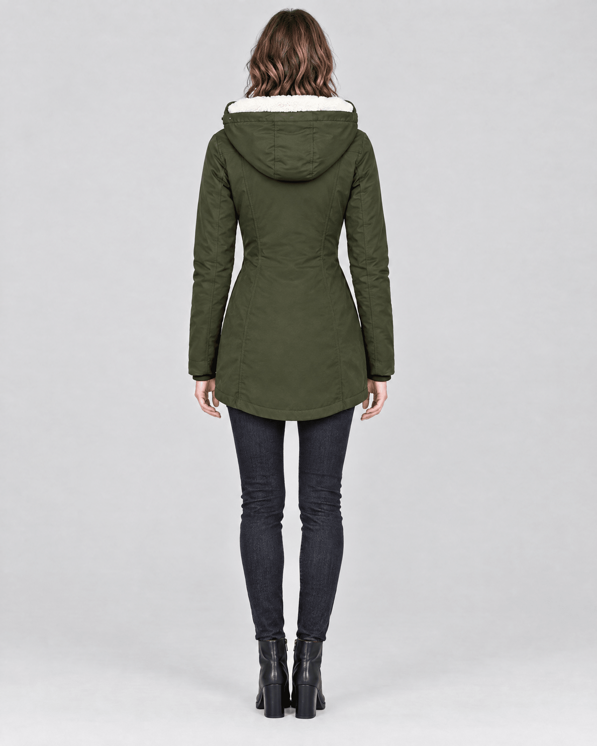 Back view of the olive green winter jacket featuring an attached hood, shaped waist, long sleeves, and curved hem.