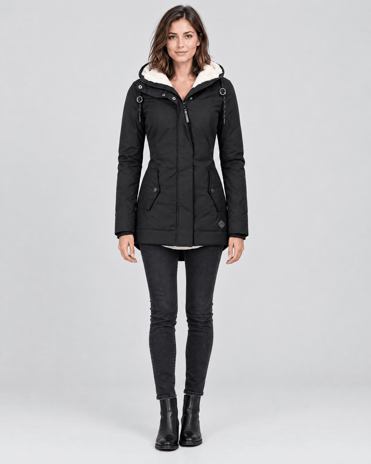 Front view of the black hooded winter jacket worn with the hood open, highlighting its neat silhouette and angled front pockets.