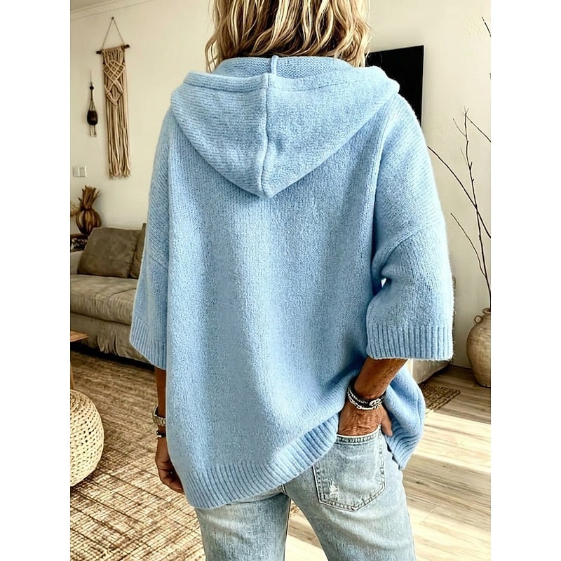 Back view of the light blue cardigan, showing the hood, relaxed silhouette, and longer ribbed back hem.