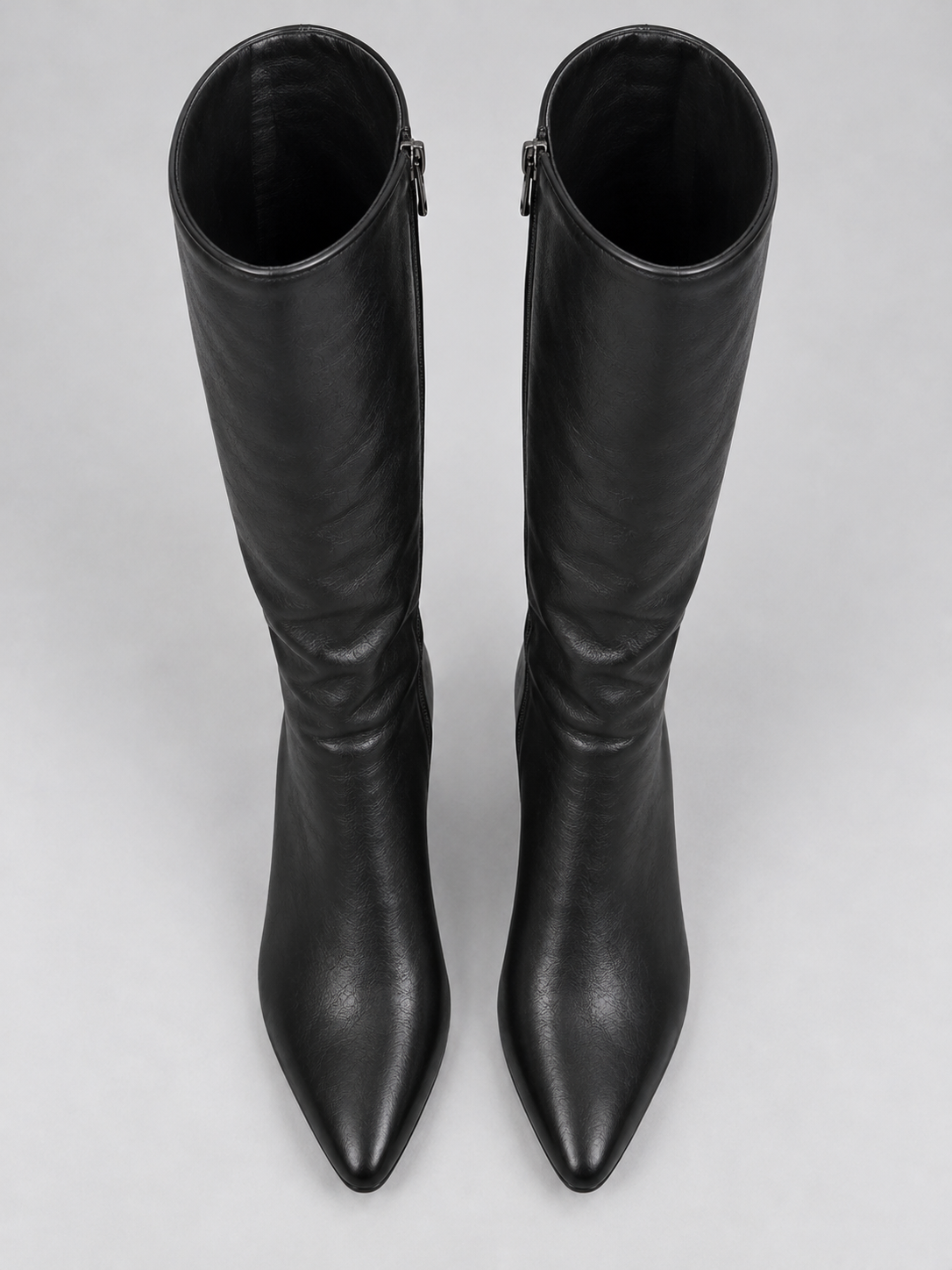 Top-down view of the pair of black knee-high boots, clearly showing their pointed toes, softly gathered shafts, and open shaft openings.