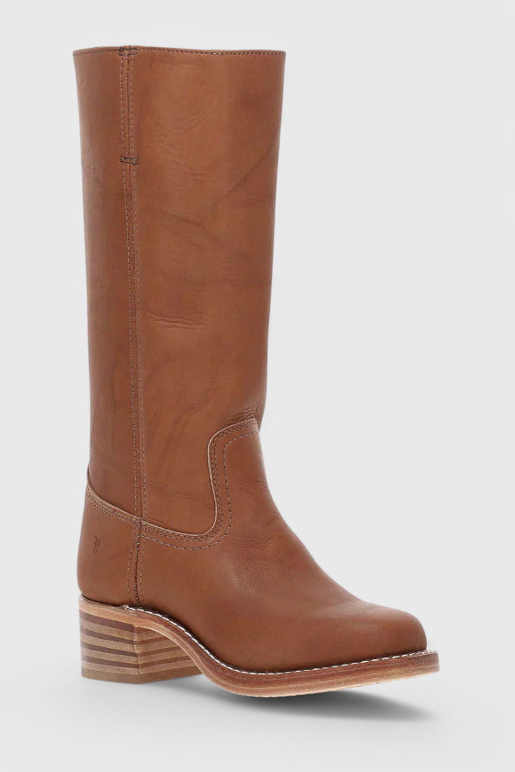 Brown knee-high boot angled toward the viewer, revealing the front opening, curved ankle panel, and layered heel.