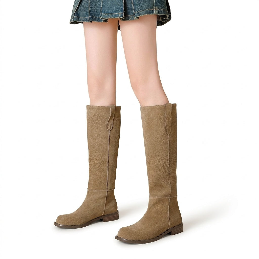 Pair of tan knee-high boots with rounded toes, vertical seams, pull tabs, and low stacked heels shown against a white background.