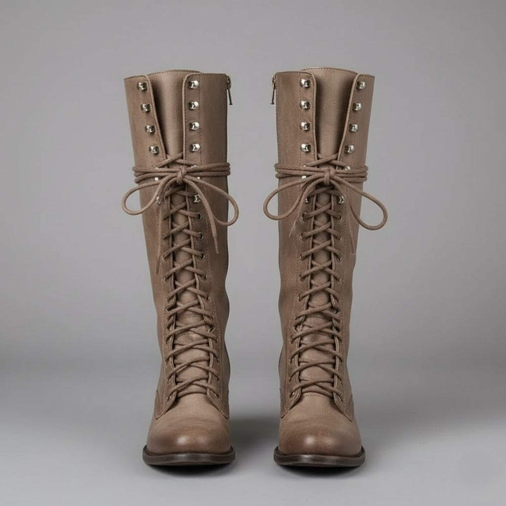 Front-facing taupe knee-high lace-up boots with long tied laces, metal eyelets, and closed round toes.
