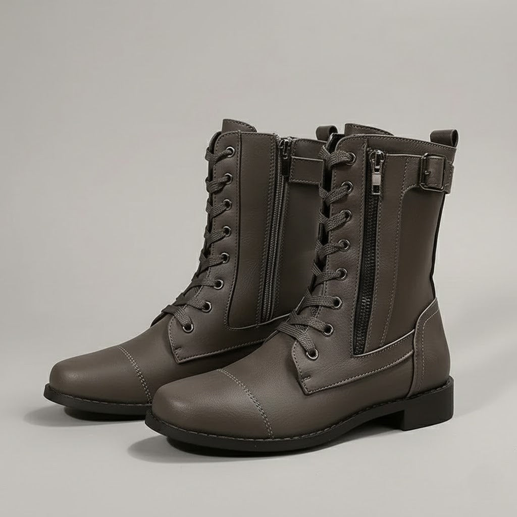 Three-quarter view of gray ankle boots displaying the lace-up fronts, side zips, ankle buckles, pull tabs, and low block heels.