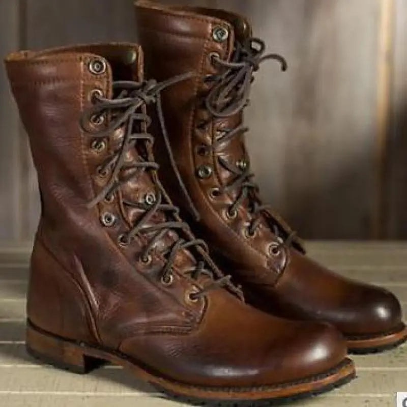 Three-quarter view of the brown lace-up boots with the cuffs folded down, showing the eyelet detail, rounded toes, low stacked heels, and patterned lining.