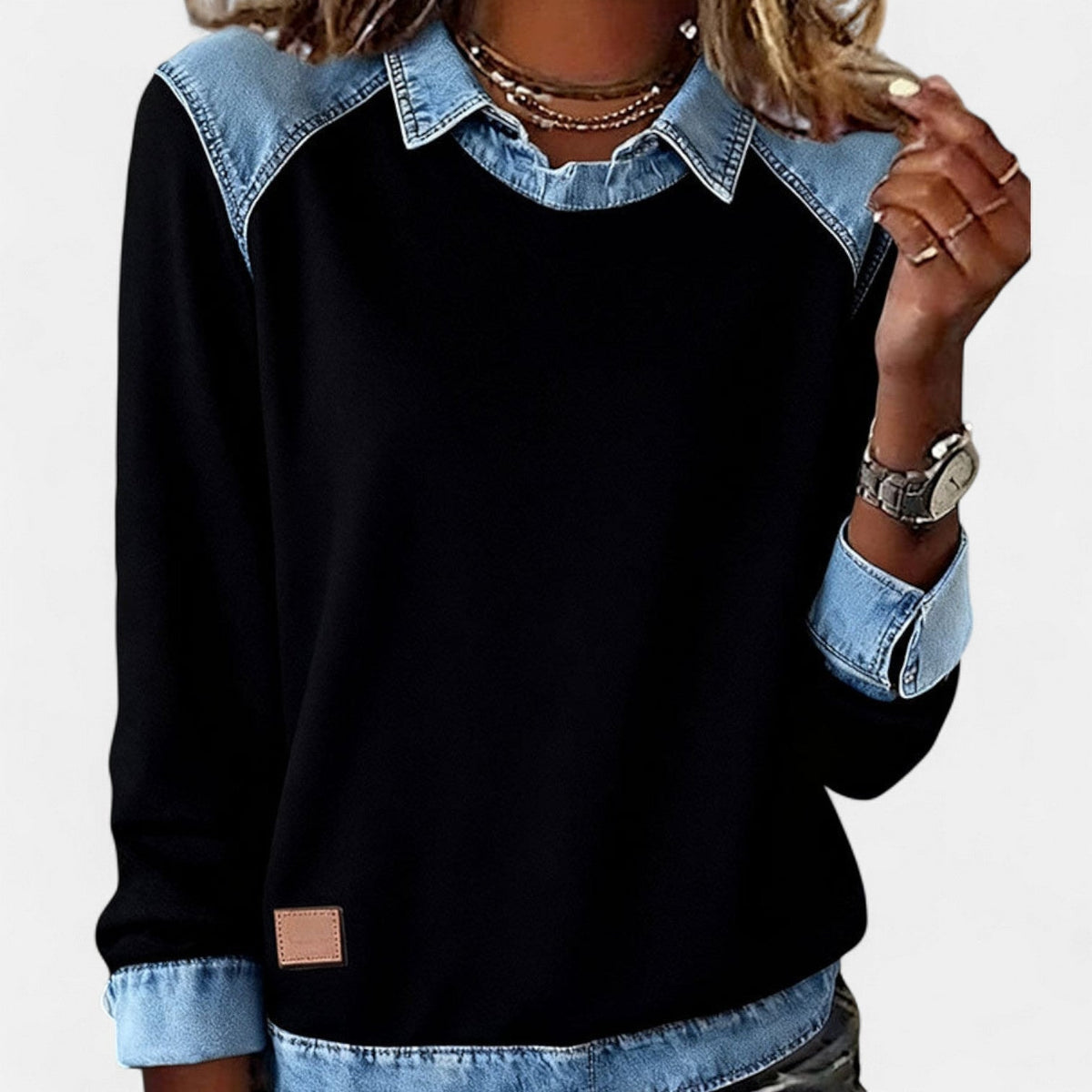 Front view of the black version of the sweater with blue collar, shoulder panels, cuffs, and hem.
