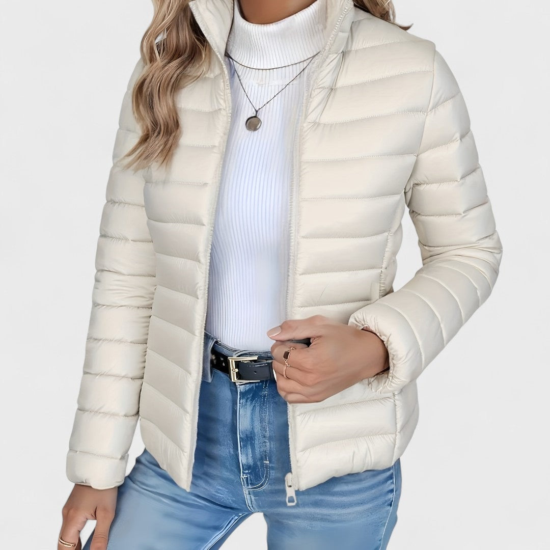 Cream quilted jacket shown from the front with the zipper closed near the bottom and the stand collar folded outward.