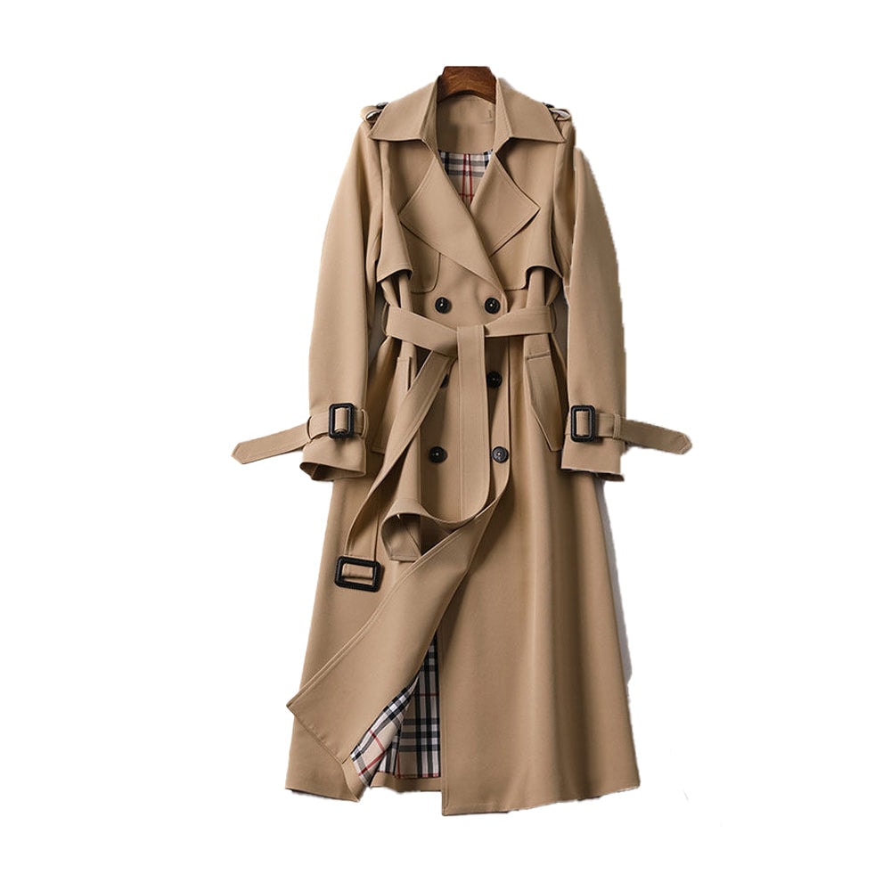 Tan long double-breasted trench coat with a tied waist belt, buckled cuff tabs, shoulder epaulettes, storm flap, and plaid-patterned inner lining visible through the open front.
