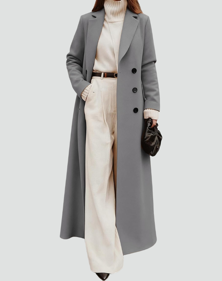 Long gray double-breasted coat with notched lapels, shown over a cream turtleneck and light trousers.