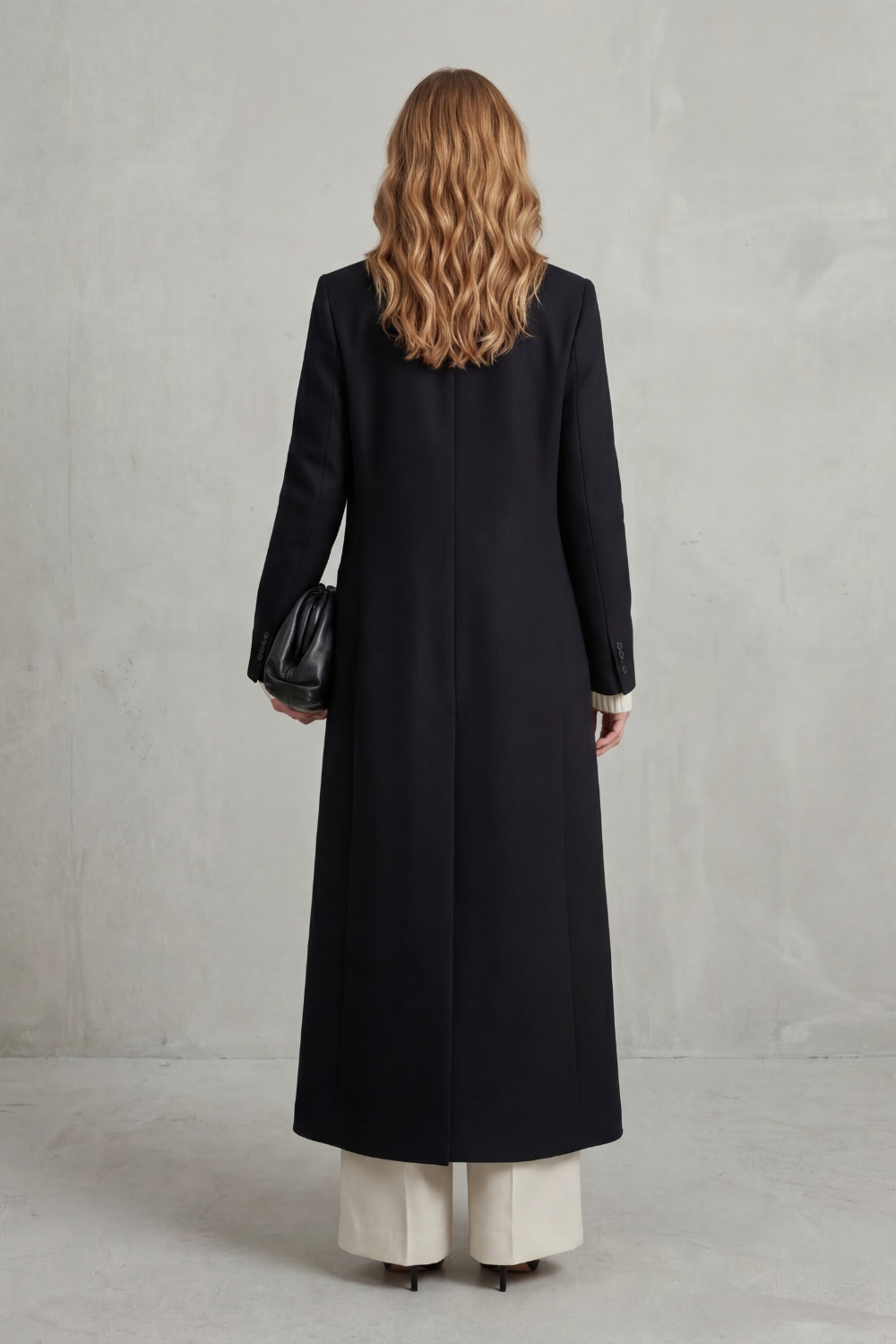 Back view of the black full-length coat, showing the clean straight silhouette and center back seam.