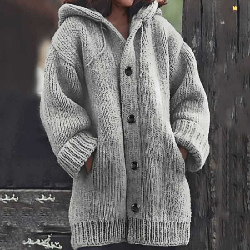 Light gray long cardigan featuring a textured chunky knit, attached hood, button closure, and ribbed edging.