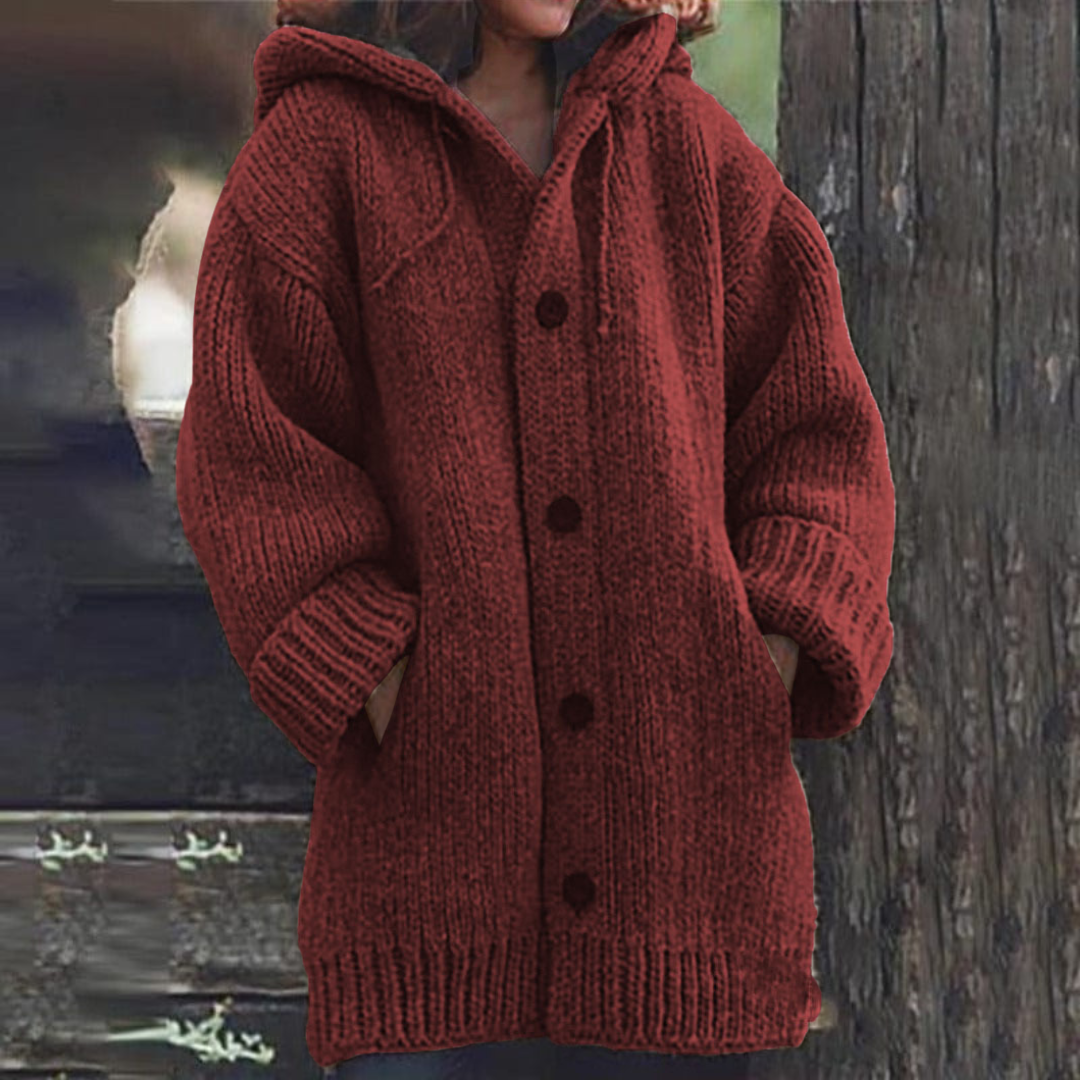 Deep red hooded cardigan with a long silhouette, chunky knit texture, dark front buttons, and front pockets.