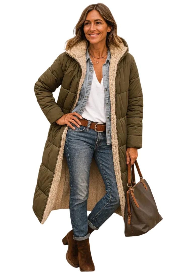 Model wearing an olive long quilted coat with one hand on the hip and a handbag, highlighting the full-length silhouette.