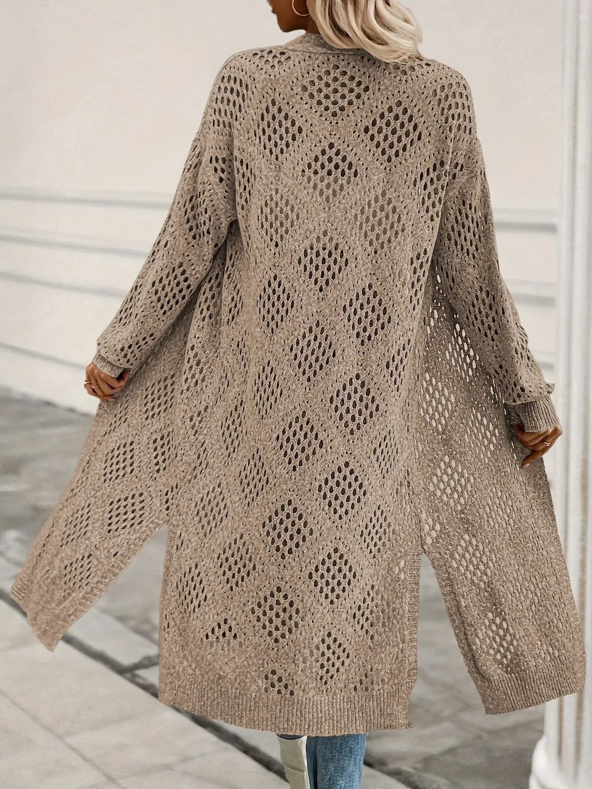 Back view of the long cardigan displaying the repeating diamond openwork pattern, full sleeves, flowing shape, and split lower sides.