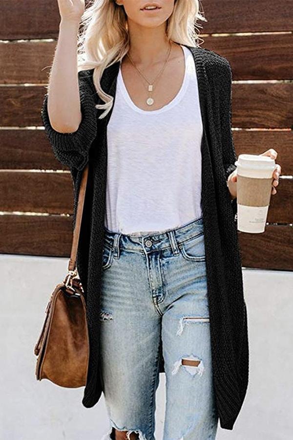 Black long open-front cardigan with relaxed sleeves layered over a white top.
