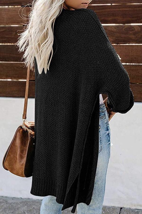 Back view of the black cardigan showing its long draped shape, loose sleeves, and ribbed hem.