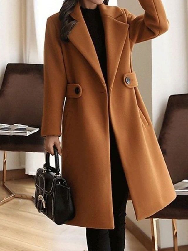 Front view of a camel long trench coat with wide lapels, two waist-tab buttons, long sleeves, and a structured below-knee silhouette.