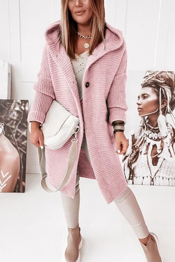 Pink longline cardigan worn open from the front, with hood, button placket, and long sleeves visible.