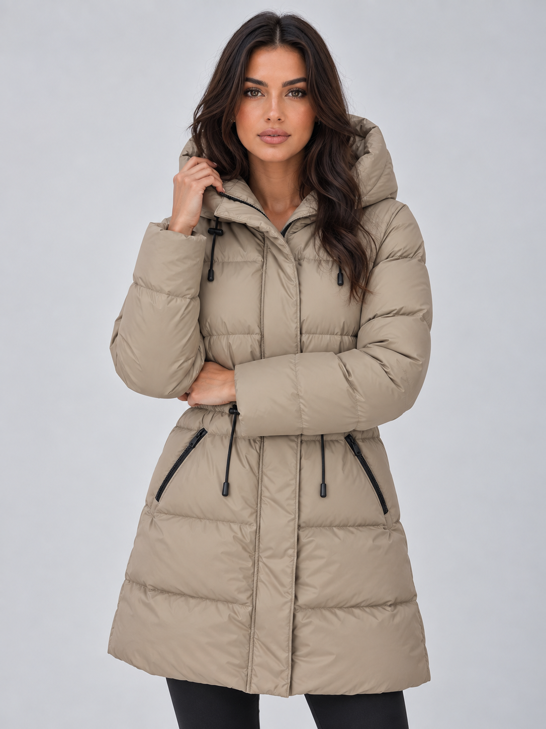 Front view of the light beige hooded puffer coat with the hood raised, long sleeves, drawstring waist, and zipped pockets.
