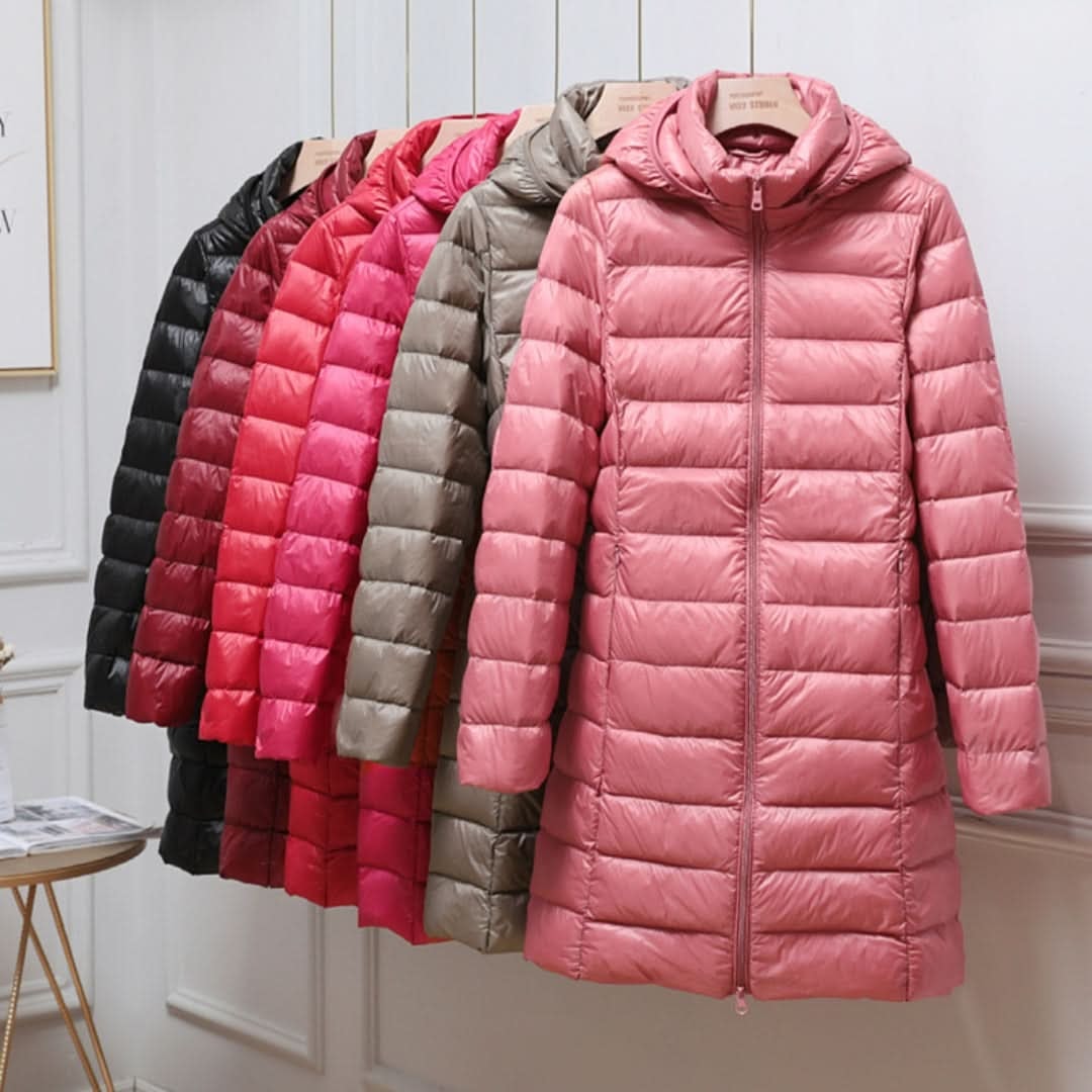 Longline hooded puffer jacket shown in pink at the front, with additional color options arranged behind it.