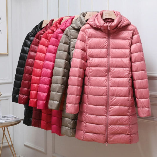 Longline hooded puffer jacket shown in pink at the front, with additional color options arranged behind it.