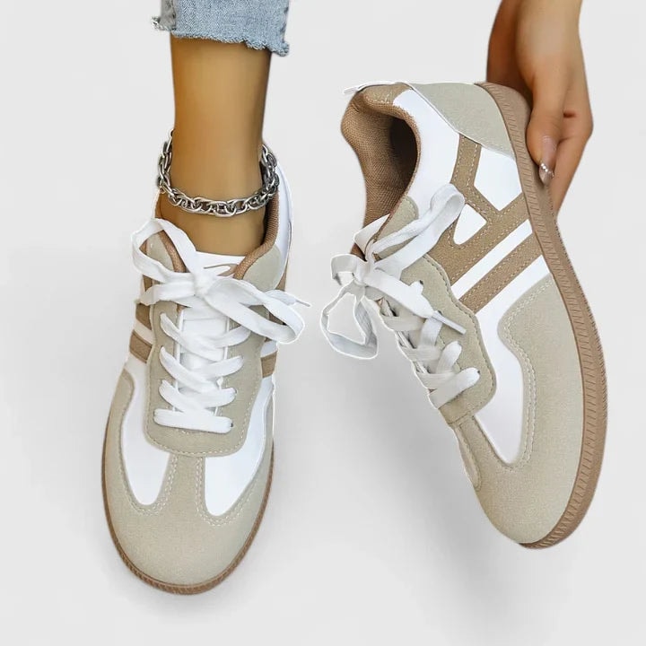 Pair of low-top lace-up sneakers viewed from above, highlighting the white laces, rounded toes, contrast paneling, and textured outsole edges.