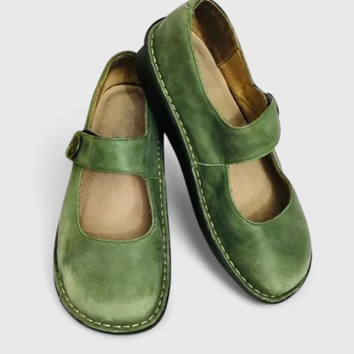 Pair of green Mary Jane flats displayed diagonally, highlighting the overlapping shoes and low-profile soles.