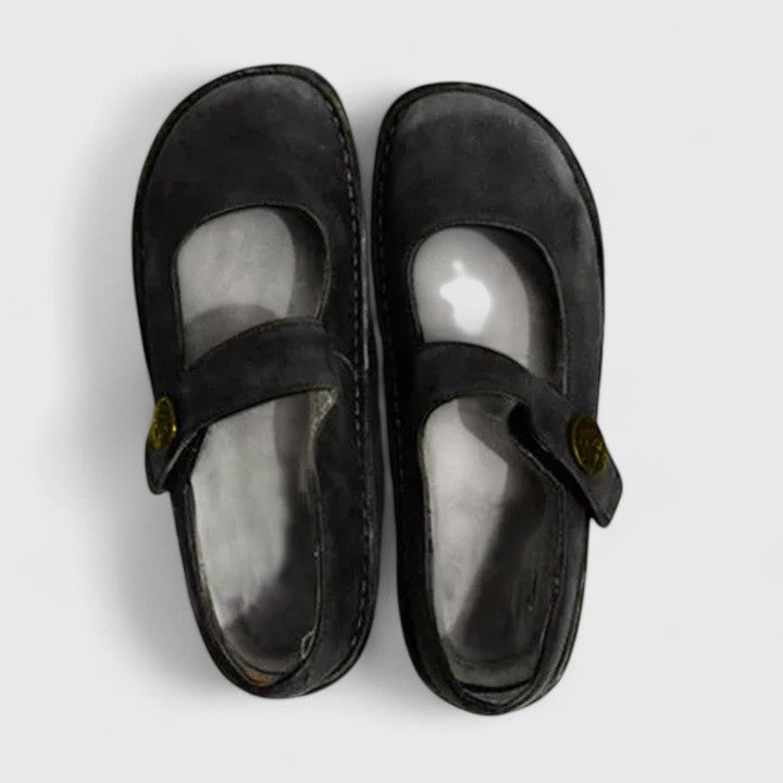 Black Mary Jane flats displayed from above, emphasizing their rounded toe profile, open vamp design, and side fasteners.