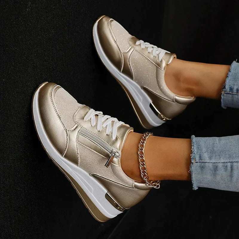 Top-down view of champagne metallic sneakers showing the lace-up fronts, side zips, and raised platform soles.