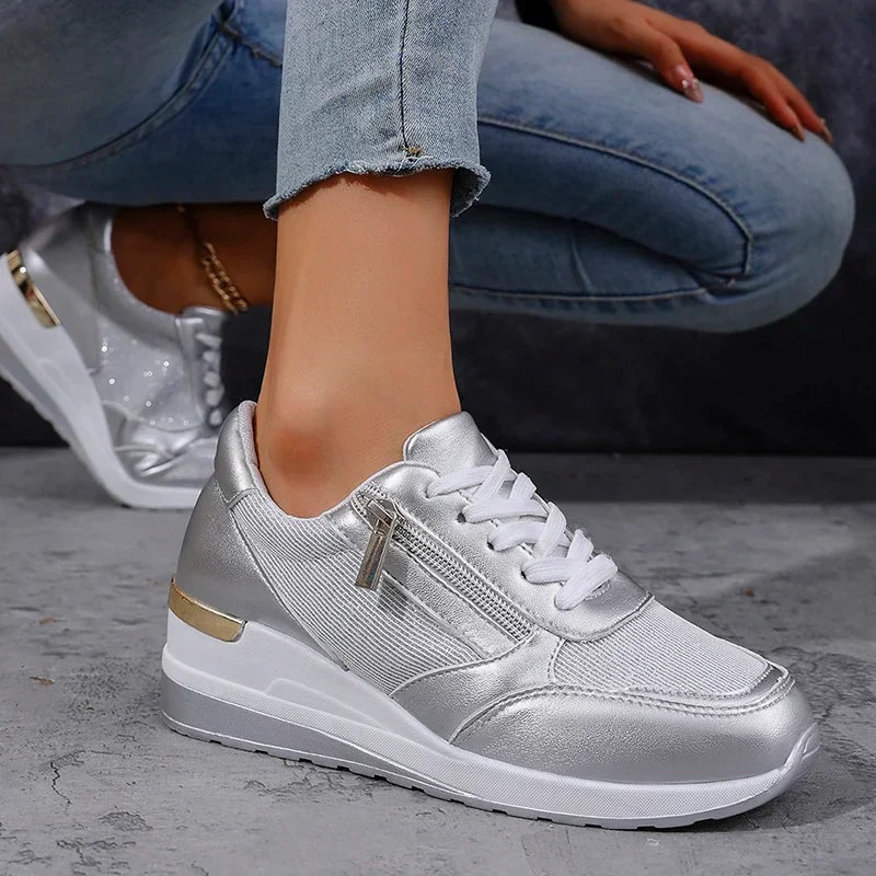 Single silver metallic platform sneaker in profile, clearly showing its white laces, side zip, and layered sole.