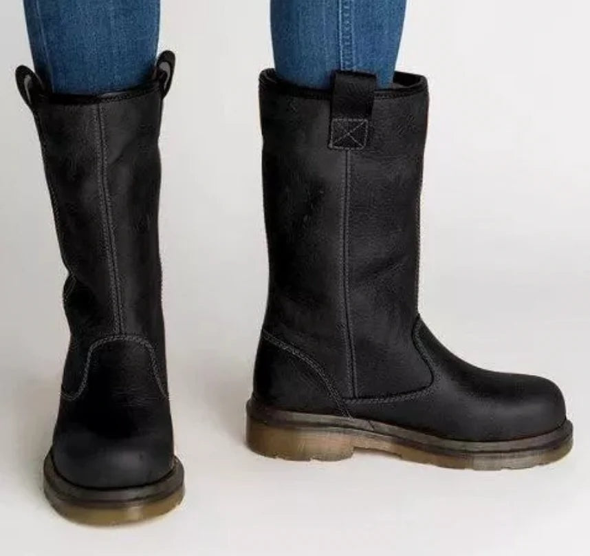 Pair of black mid-calf pull-on boots with round toes and rear tabs, featuring visible stitching, low heels, and sturdy treaded soles.