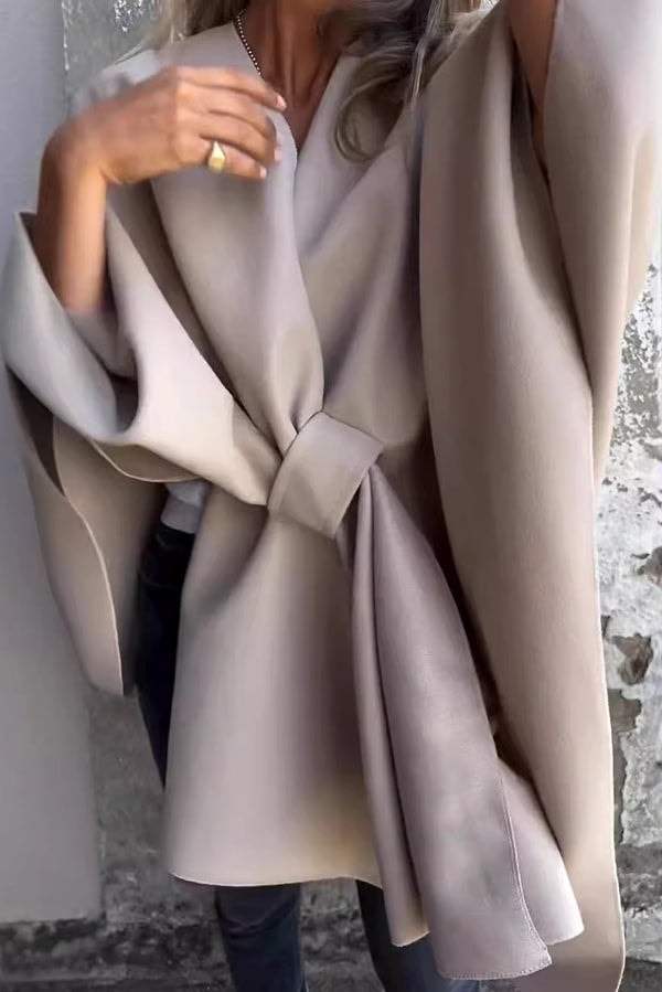 Taupe open-front cape jacket shown tied at the waist, with layered drape and wide sleeves.