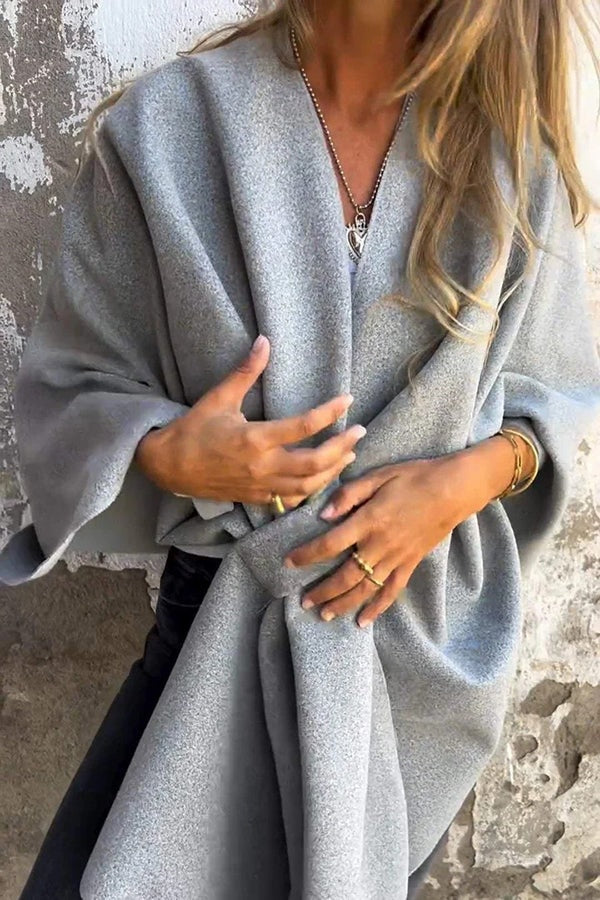 Light gray cape jacket shown from the front with overlapping panels, a gathered waist, and wide sleeves.