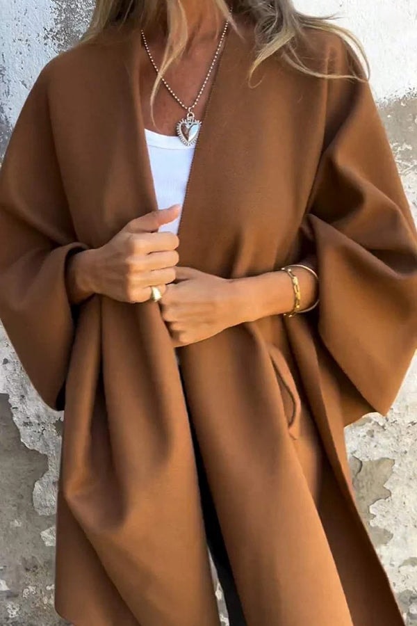 Brown open-front cape jacket shown in a close front view, revealing its long draped panels and roomy sleeves.
