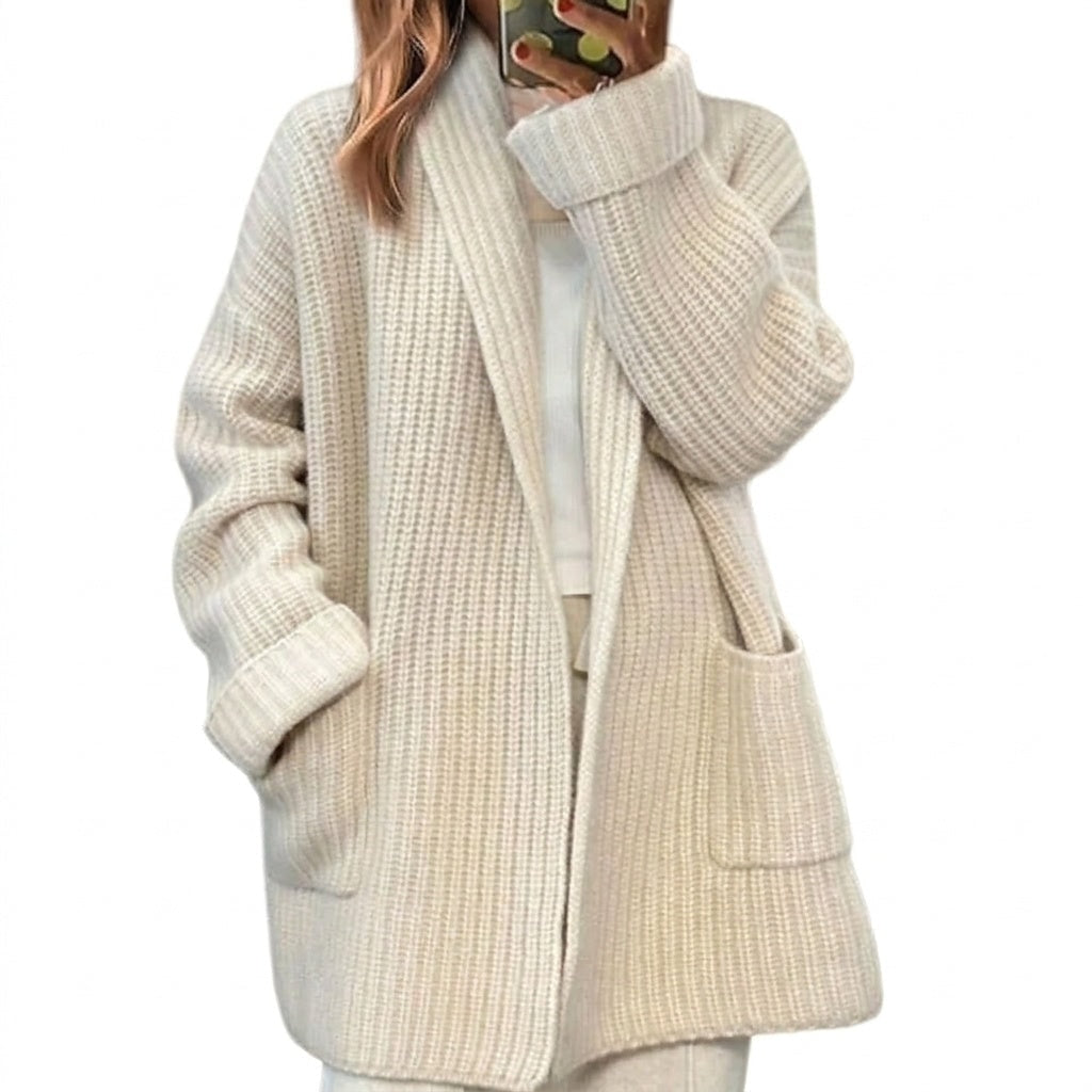 Light cream open-front ribbed cardigan with long sleeves, wide turn-back cuffs, and two front patch pockets, shown over a light top.