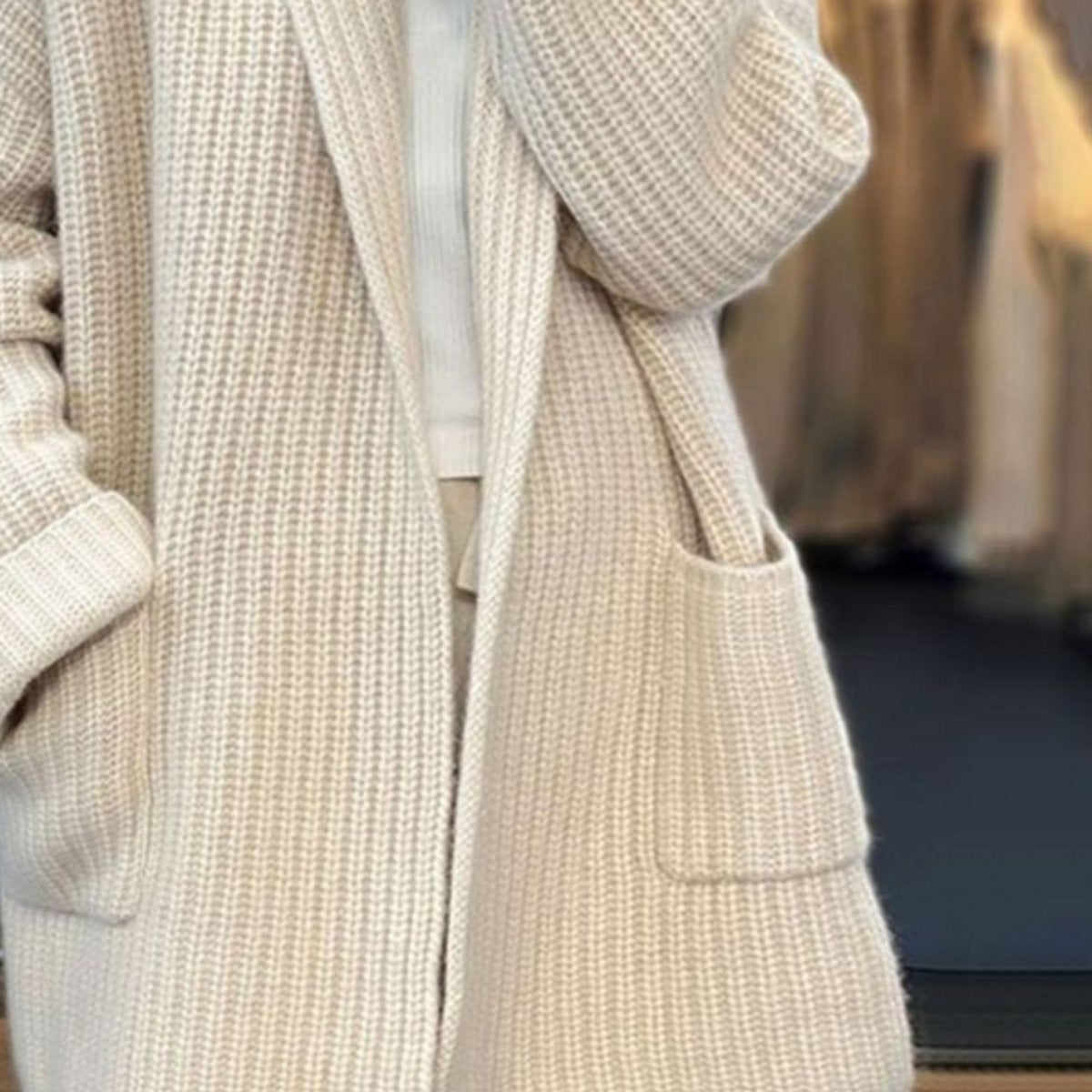 Close view of the cardigan’s vertical ribbed texture, open front edge, and large front patch pocket.