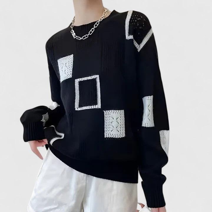 Black patchwork crew neck sweater shown from a side angle, highlighting the white openwork shoulder, sleeve accents, and ribbed cuffs.