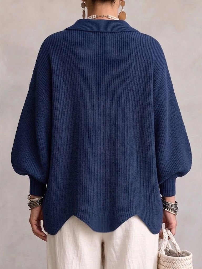 Back view of the navy oversized cardigan showing its relaxed drape, voluminous sleeves, ribbed cuffs, and curved hem.