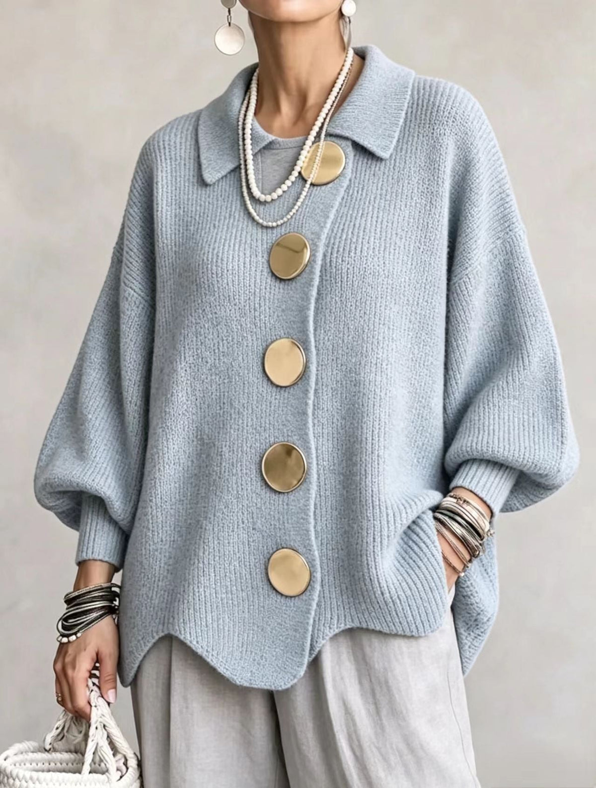 Light blue oversized cardigan with a pointed collar, five large round buttons, balloon sleeves, and defined ribbed cuffs.