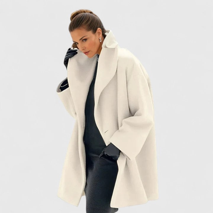 Cream oversized coat with wide lapels and long sleeves, shown open in a front three-quarter view.